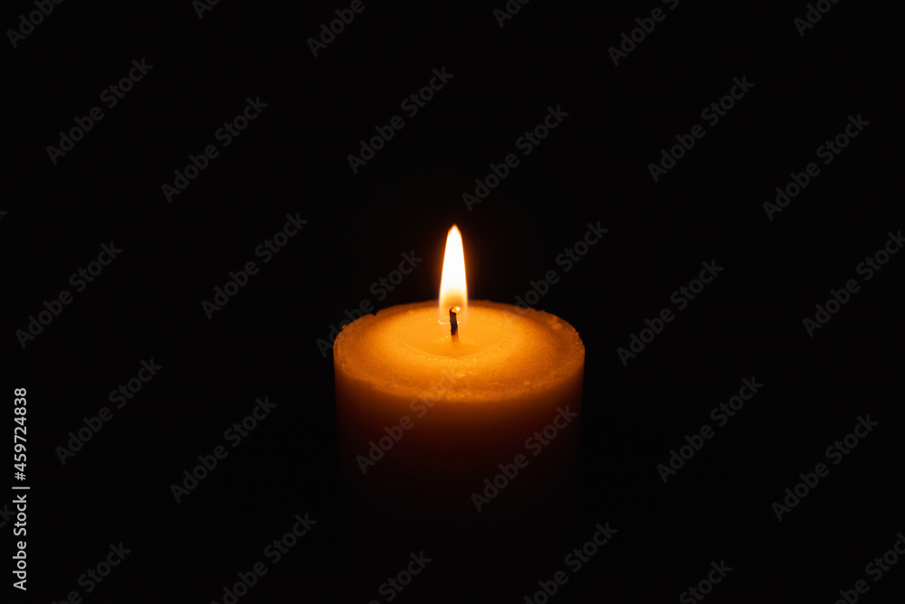 One single light candle burning brightly in the black background.Spiritual candle yellow flame. Flame of candle in the darkness.Copy space. One single light candle burning brightly in the black background.Spiritual candle yellow flame. Flame of candle in the darkness.Copy space.