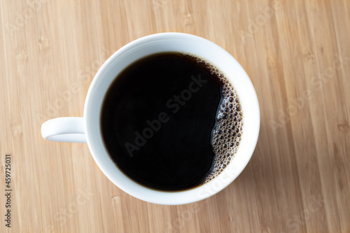 Coffee cup on wood table top view, isolated 