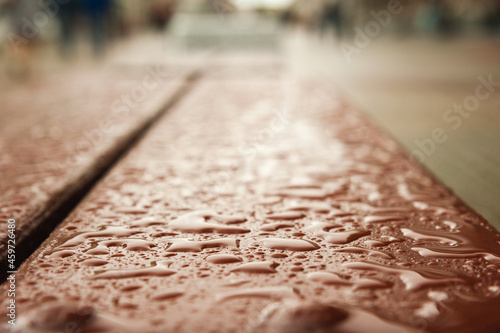 Photo of raindrops on a bench with soft focus and copy space.