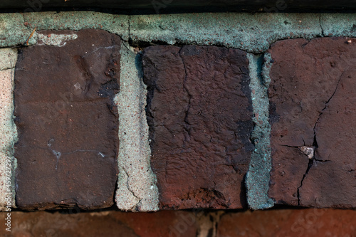 Old bricks from the fence of 20th century building. Detail of hand made bricks, cracked and weathered over time. © Tuisku