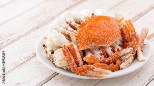 steamed crabs in white ceramic plate on white old wood texture background with copy space for text, blue swimming crab, flower crab, blue crab
