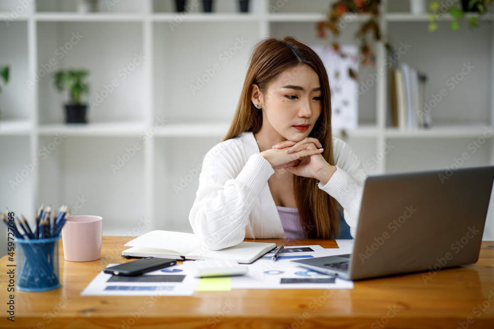 Asian young businesswoman working on desk office with using a calculator to calculate the numbers, finance accounting concept. Asian young businesswoman working on desk office with using a calculator to calculate the numbers, finance accounting concept.