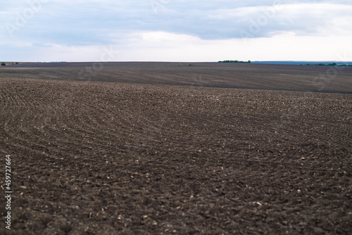 Plowed soil in spring time with blue sky.Preparing field for planting. 