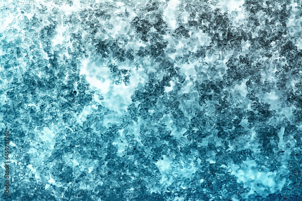 Close-up snow texture on the window with a beautiful gradient in blue and light blue tones. Close-up snow texture on the window with a beautiful gradient in blue and light blue tones.