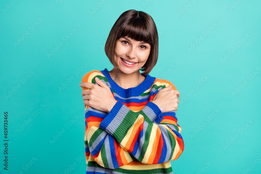 Photo of young woman happy positive smile embrace herself cozy enjoy isolated over teal color background Photo of young woman happy positive smile embrace herself cozy enjoy isolated over teal color background