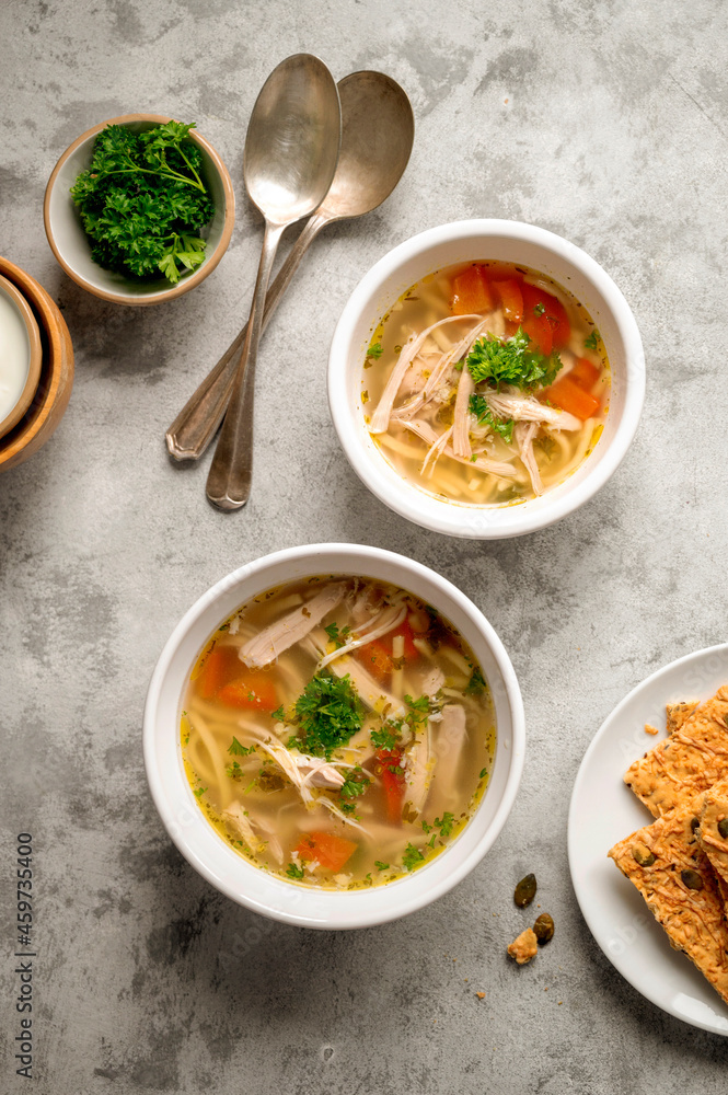 Chicken noodle soup, two bowls with vegetable broth, top view. Chicken noodle soup, two bowls with vegetable broth, top view.