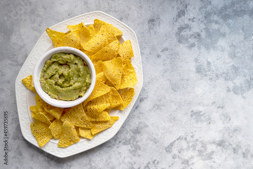 Healthy snack, nachos chips and homemade guacamole, tortilla chips snack. Party food. Top view.