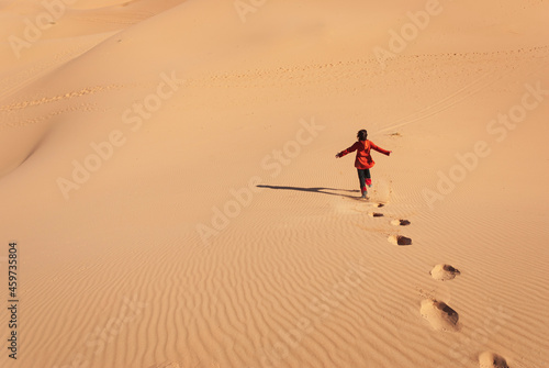 woman running happily down a desert dune