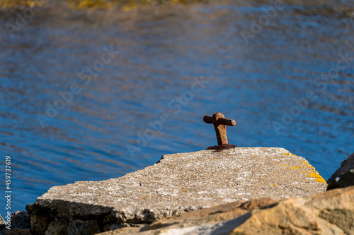 Old rusty mooring bollard at the rock at Lindesnes Lighthouse.