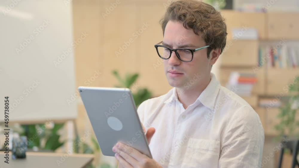 Portrait of Attractive Young Man Using Tablet in Modern Office Portrait of Attractive Young Man Using Tablet in Modern Office
