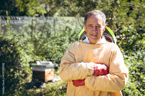 Caucasian senior man wearing beekeeper uniform and looking at camera photo
