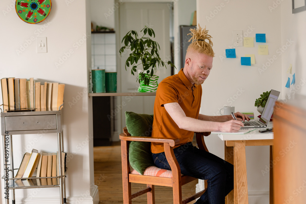 Albino african american man with dreadlocks working from home and using laptop Albino african american man with dreadlocks working from home and using laptop