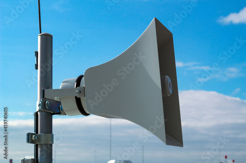 Loudspeaker of the emergency warning system against the background of a blue sky.