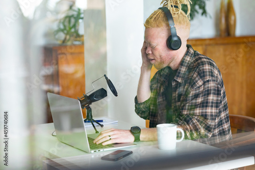 Albino african american man with dreadlocks working from home and making podcast photo