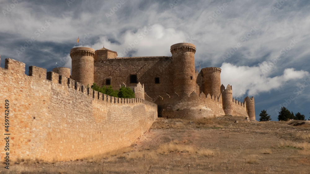 Beautiful medieval wall and architecture protecting the ancient Spanish town of Belmonte, under a dominating blue sky.