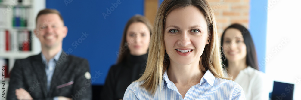 Portrait of confident business woman behind business team Portrait of confident business woman behind business team