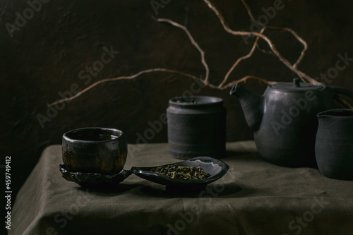 Set of craft handmade ceramic teapot and cups with dark background