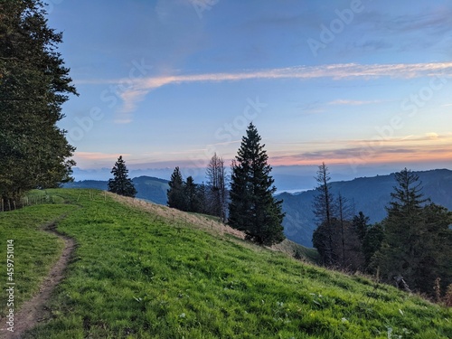 Hiking trail to the Schnebelhorn in the zurich oberland near fischenthal. Evening mood on a swiss hill. clouds blue sky photo