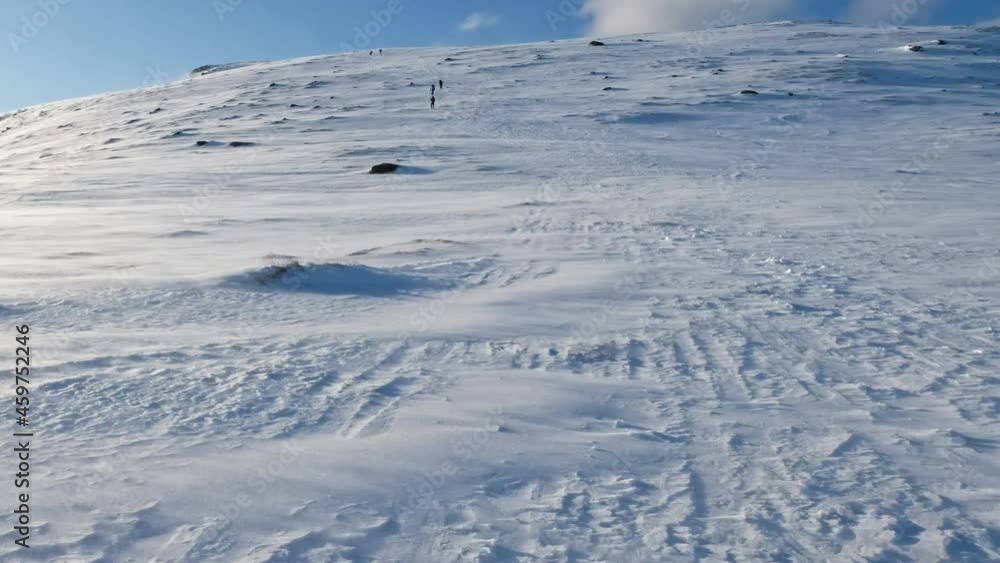Hiking on snowy hill in blizzard at Ryten mount