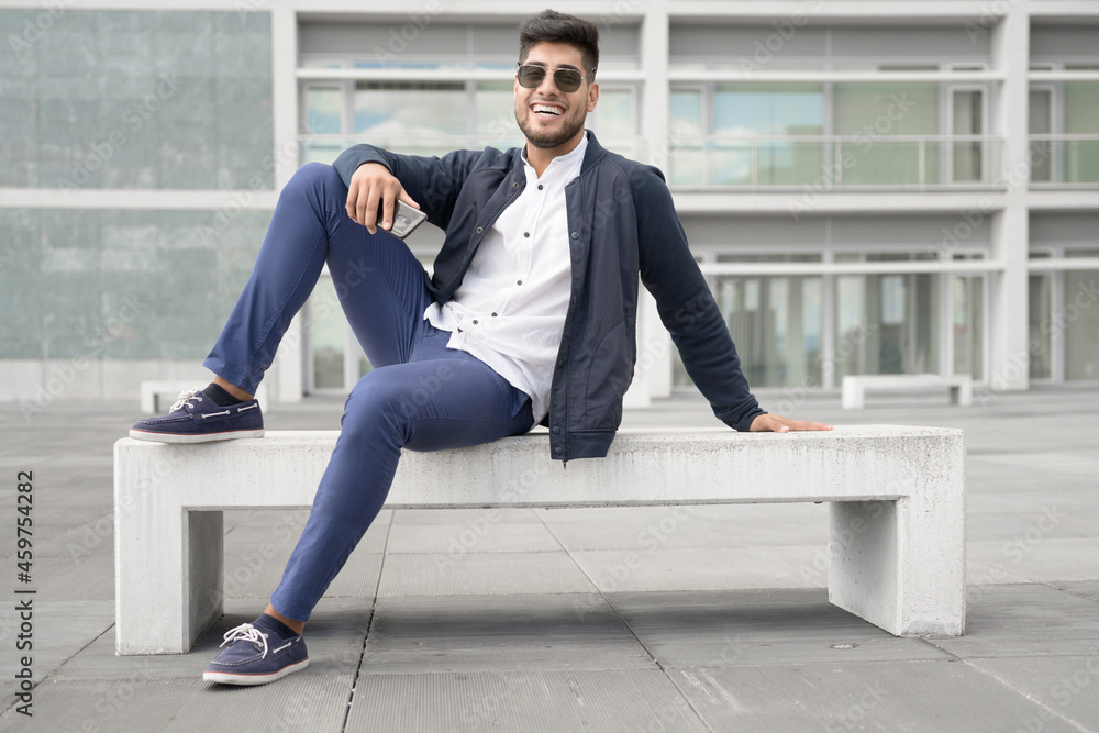 Portrait of young man in stylish sunglasses posing near modern building. High quality photo Portrait of young man in stylish sunglasses posing near modern building. High quality photo