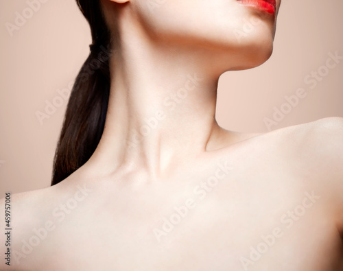 Women's chin, neck and collar bone on a nude background