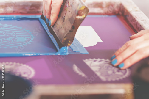 Photography screen printing with blue paint by a beautiful woman with matching painted nails