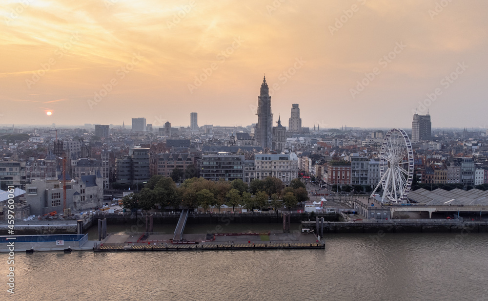 Aerial sunrise shot over the river Scheldt of Antwerp cathedral, Boerentoren and Giant Wheel The View Reuzenrad during beautiful morning golden light