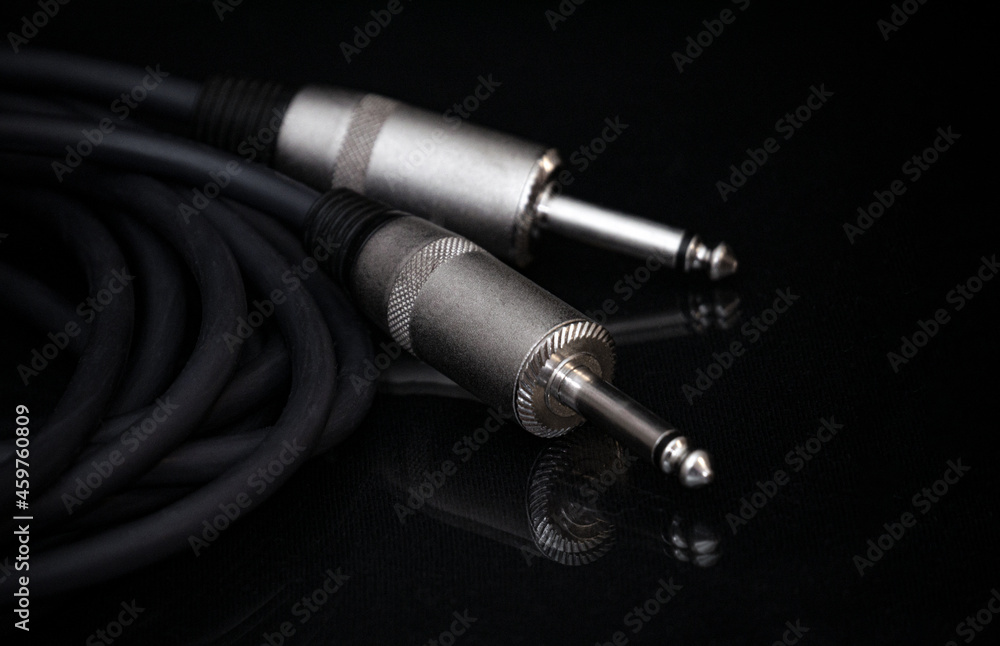 Two silver TRS connectors for the analog audio signal are placed against a black background. Professional jack connectors for sound equipment. Audiophile technologies concept. Two silver TRS connectors for the analog audio signal are placed against a black background. Professional jack connectors for sound equipment. Audiophile technologies concept.