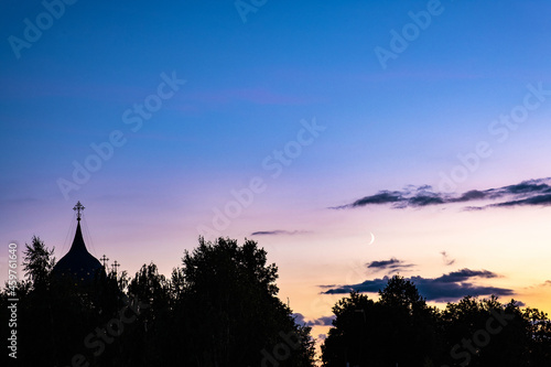 Silhouettes of trees and domes of churches on the beautiful sunset sky in Suzdal.