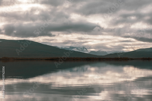 Clear lake with snowy mountain reflection and clouds