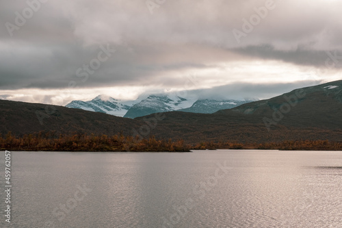 Lake and snowy mountains on a cloudy day in autumn