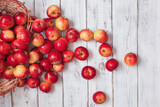 Rozsypane czerwone jabłka na starym drewnianym stole. Piękne, pyszne czerwony jabłka z sadu.
