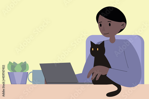 An African-American man is working at a laptop, a black cat is interfering with him. Home office, remote work during quarantine and lockdown. Home schooling via the Internet. Online work and study