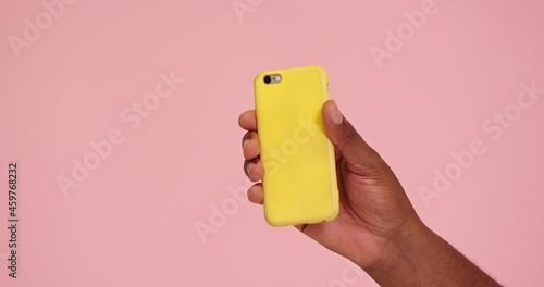 African american man hand demostrate phone isolated on pink background photo