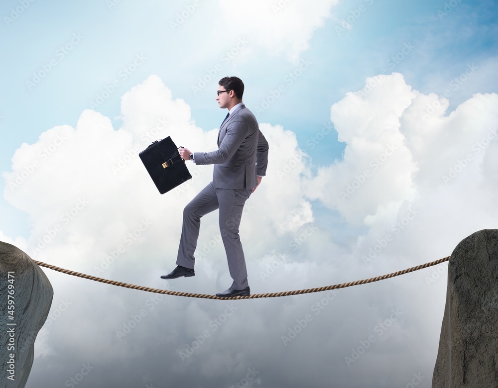 Businessman walking on tight rop in business concept Businessman walking on tight rop in business concept