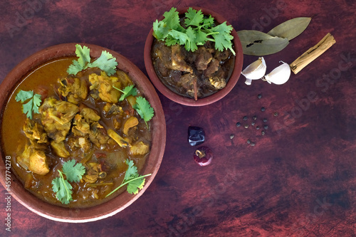 Selective focused Chicken curry-masala-country chicken kuzhambu Tamilnadu style. Mutton pepper fry with spices-mutton curry in traditional way and served in a mud pot.  photo