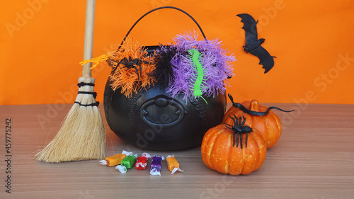 Happy Halloween concept. Decoration with halloween accessories on the table, with orange background. photo