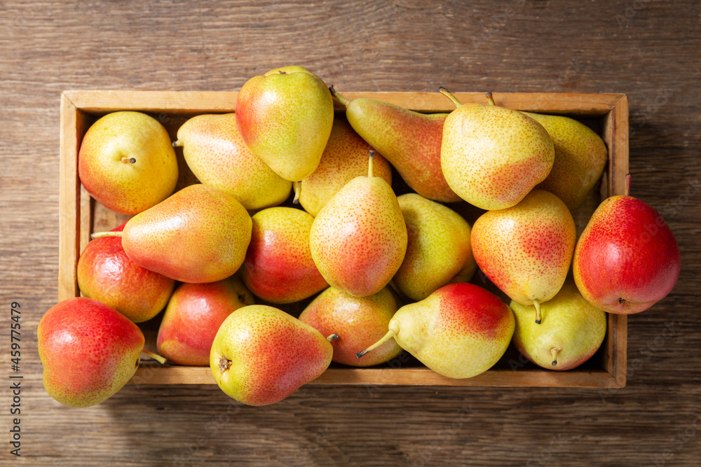 fresh ripe pears in a box on a wooden background fresh ripe pears in a box on a wooden background