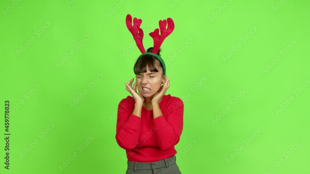 Young Woman Wearing Christmas Hat Covering Both Ears With Hands