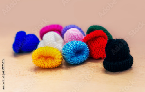 Colored woolen winter hats handmade close-up. A set of crocheted multicolored small hats  horizontal with space for copying. Winter concept