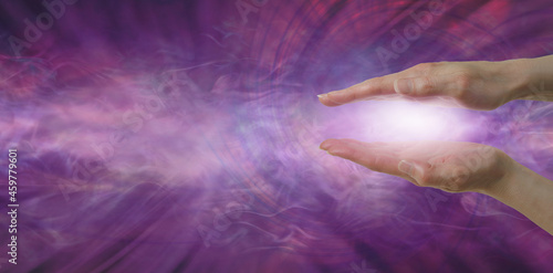 Reiki Magenta Healing Message Banner Background - Healer with parallel hands and pink light between against an ethereal flowing energy field background with space for copy 