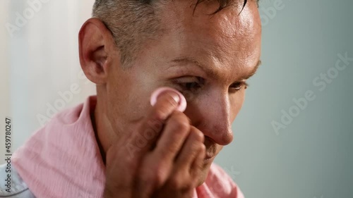 Close Up portrait of Man putting makeup on his face photo