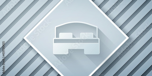 Paper cut Hotel room bed icon isolated on grey background. Paper art style. Vector