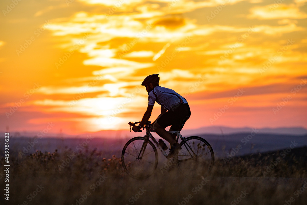 Naklejka premium cyclist silhouette at sunset sports and fitness concept