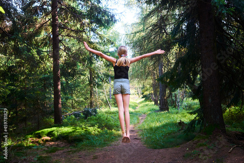 Young girl flying in the air in the woods. Jumping for freedom