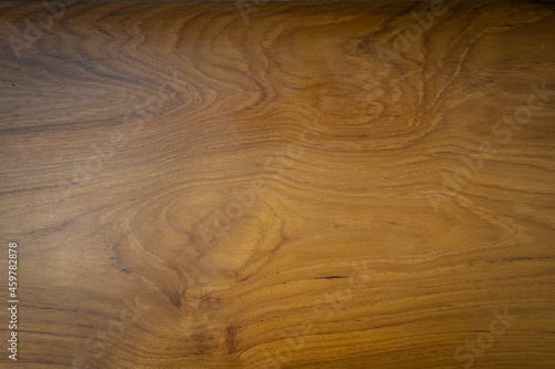 The teak wood background is coated with a matt lacquer showing the wood grain.