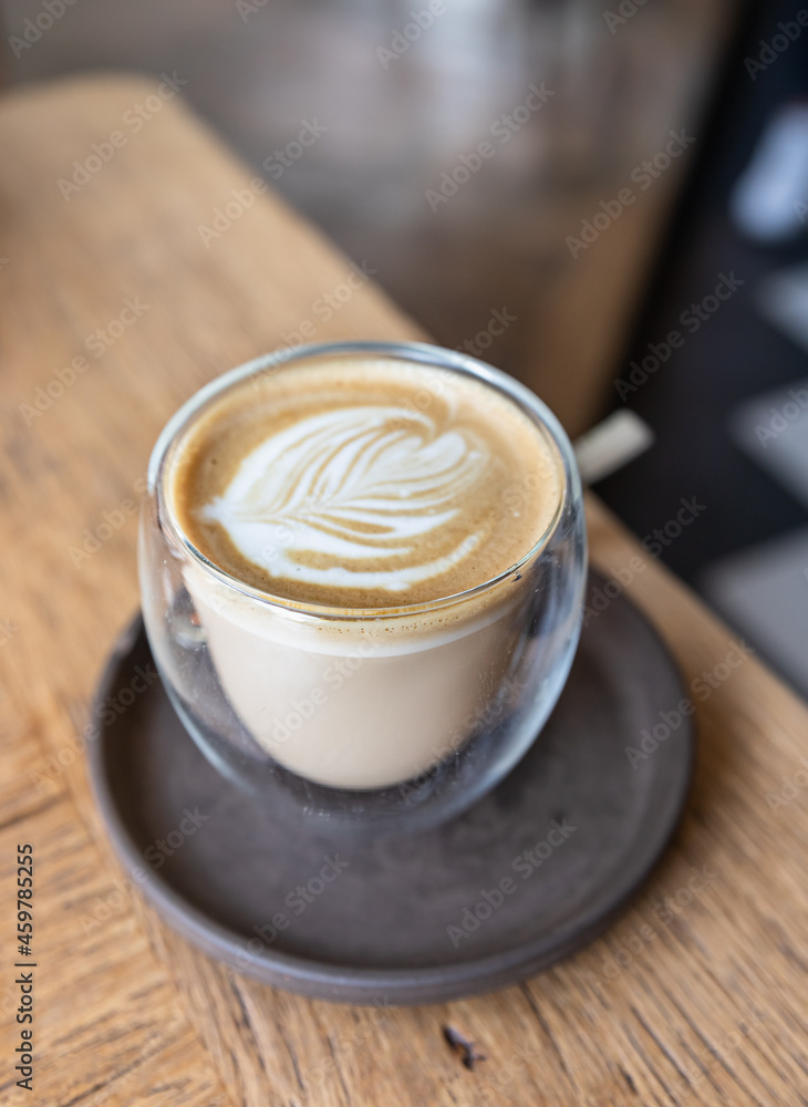 Coffee with latte art in cup on wooden table in cafe or coffee shop. Coffee with latte art in cup on wooden table in cafe or coffee shop.