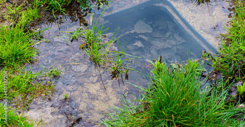 manhole drainage grates on the lawn with green grass septic tank cover, sump cesspool drainage system environment design side view with copy space, nobody.