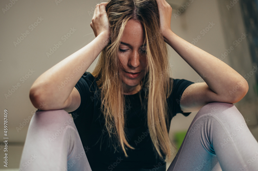 Obraz premium Stressed tired woman holding her head in pain
