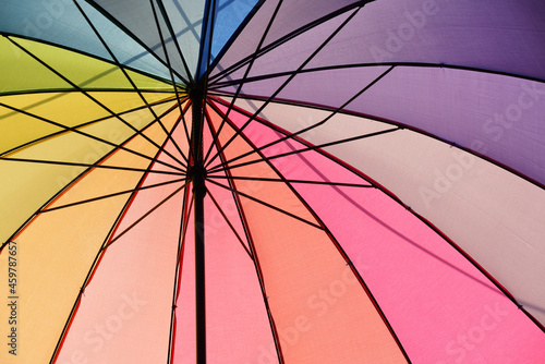 Close up of a colorful open umbrella in the colors of the rainbow